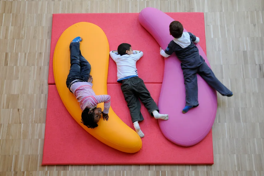 Children using comma-shaped soft seating for collaborative learning